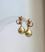 Elegant cat earrings with genuine saltwater South Sea pearls, warm golden tea color, and intense luster.