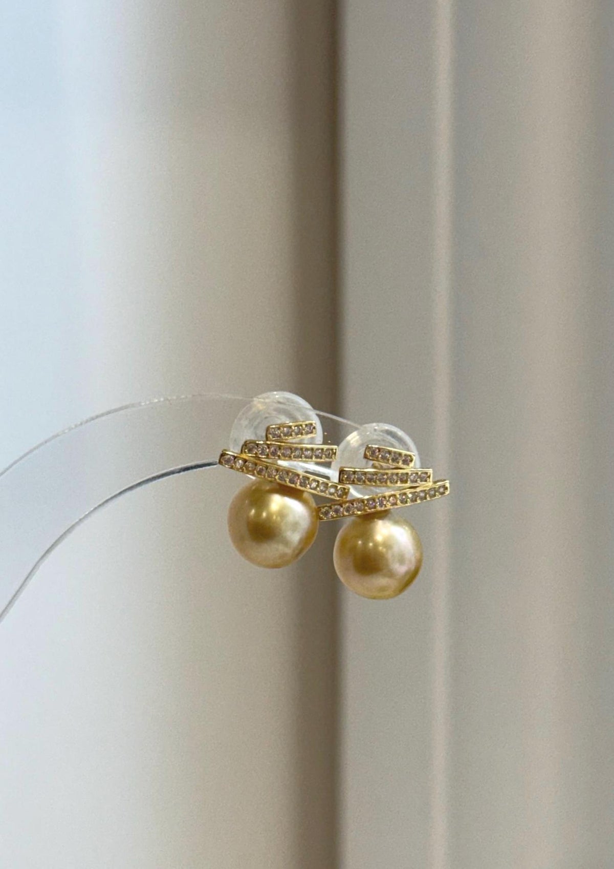 Real saltwater South Sea pearl earrings with warm deep tea golden color and refined geometric accents.