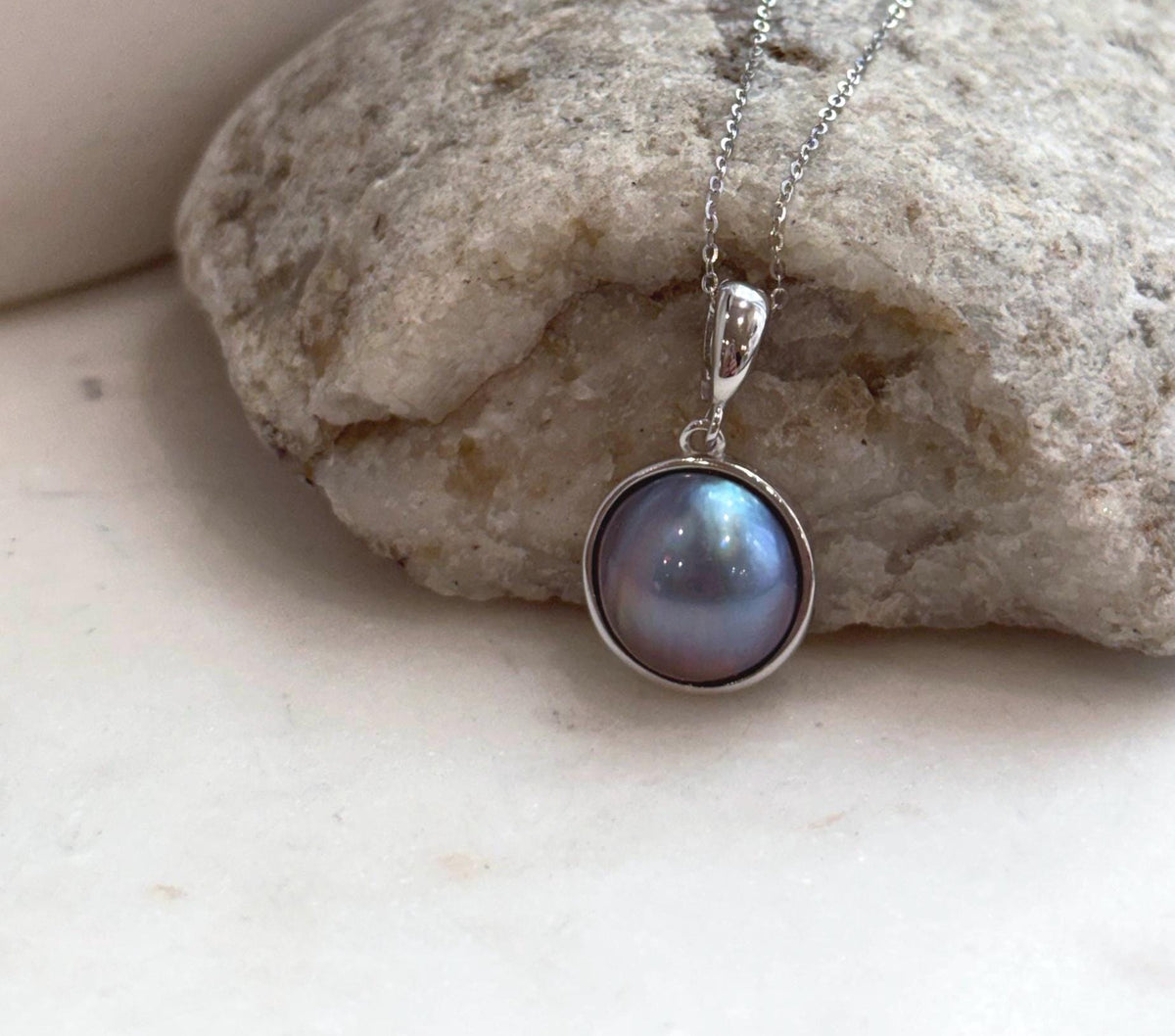 Purple iridescent Ocean Mabe pearl pendant showing beautiful natural overtones and mirror-like shine