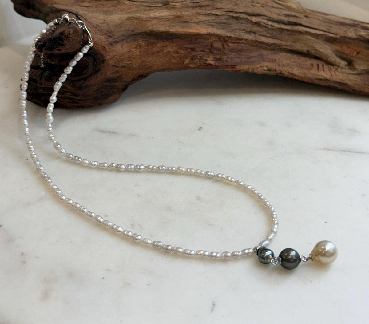 Natural pearl necklace featuring three colorful pearl drops on a fine white pearl strand