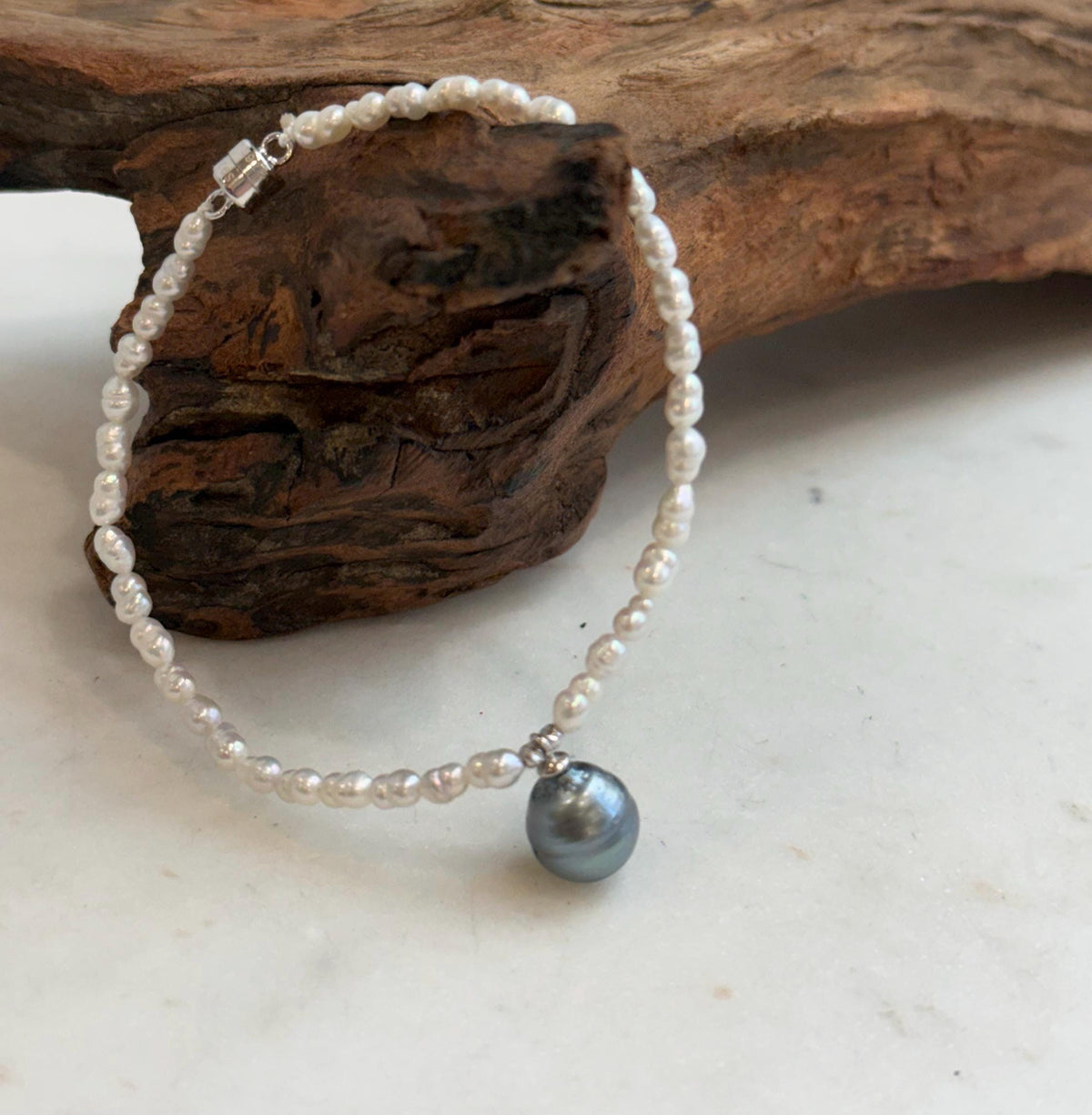 Natural dark silver Tahitian pearl paired with lustrous white mini pearls