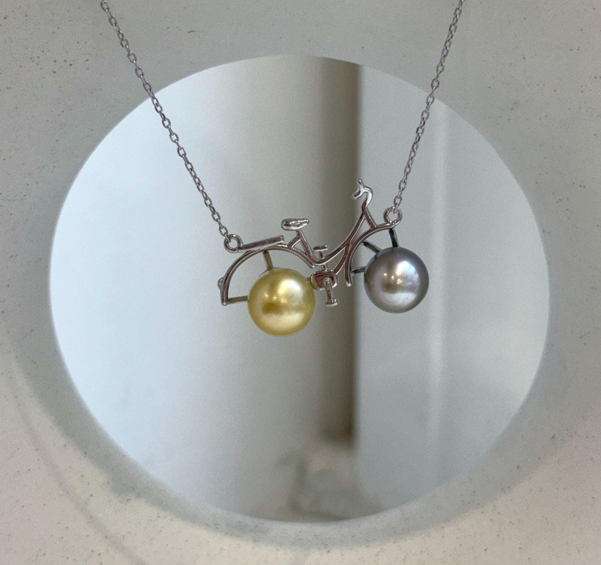 Double pearl bicycle pendant necklace with natural Tahitian and South Sea pearls.