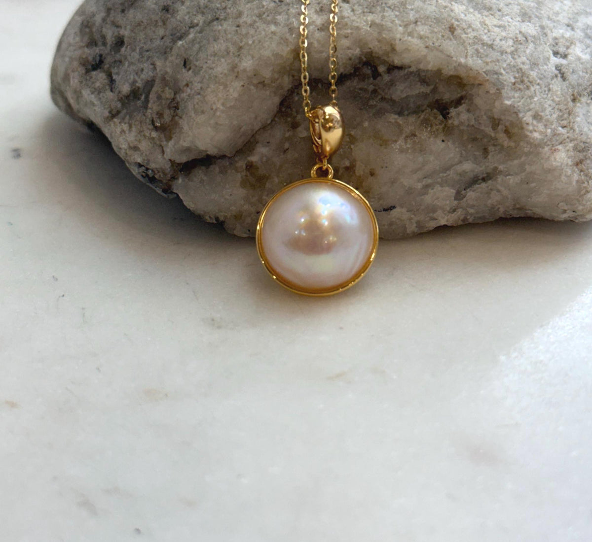 Iridescent ocean pearl necklace with a classic round pendant design