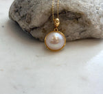 Iridescent ocean pearl necklace with a classic round pendant design
