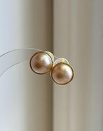 High-luster Mabe pearl earrings with a smooth reflective surface