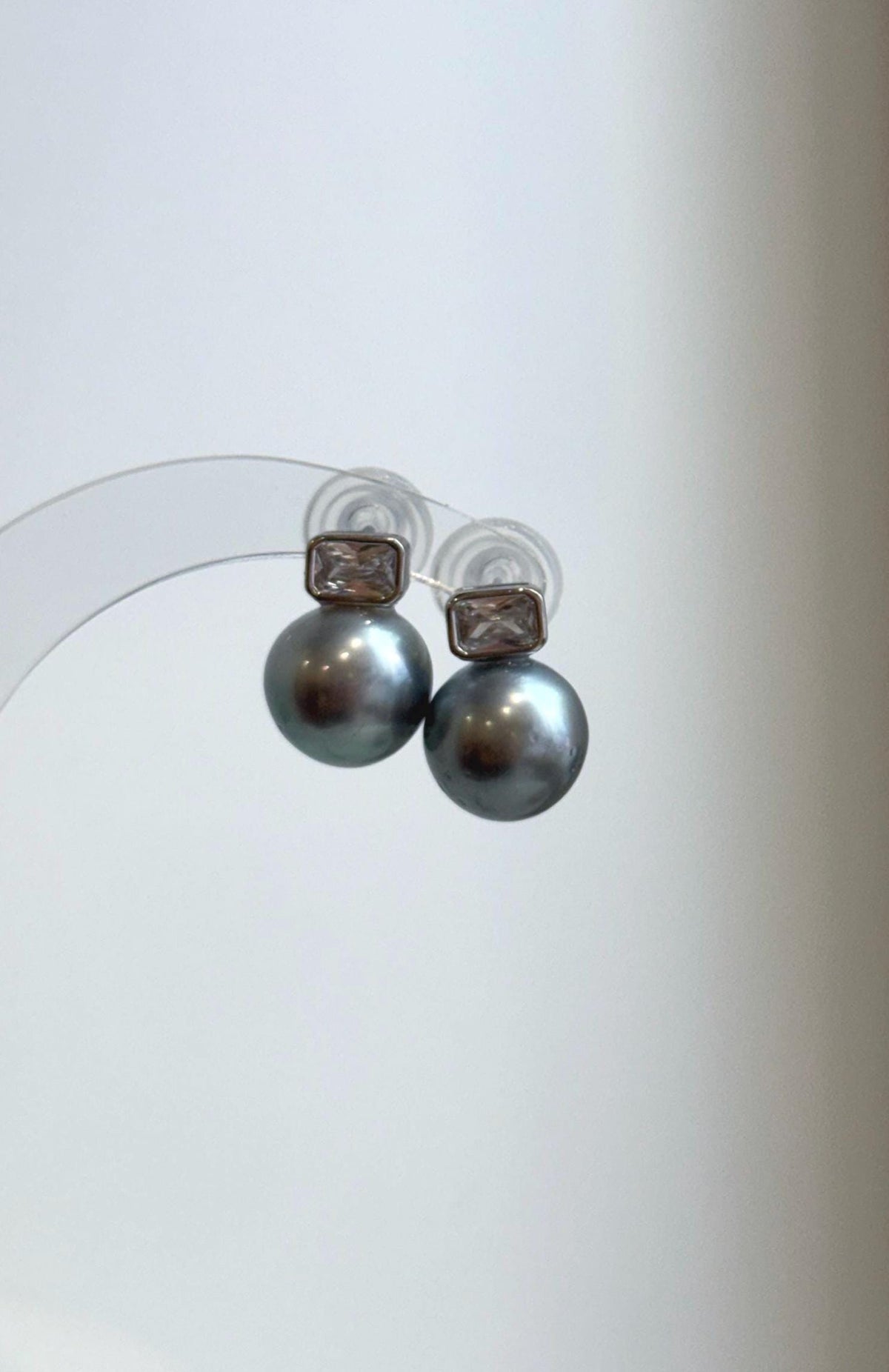 Front view of platinum Tahitian pearl earrings with rectangular gemstone tops