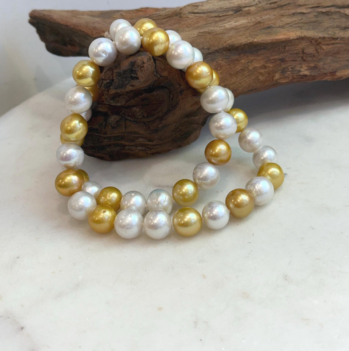 Golden Edison pearls interspersed with white pearls along a single strand necklace.