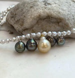 Front view of the white pearl necklace with five pearl drops across the center.