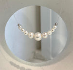 White pearl necklace with a nearly invisible clear nylon cord creating a floating effect.