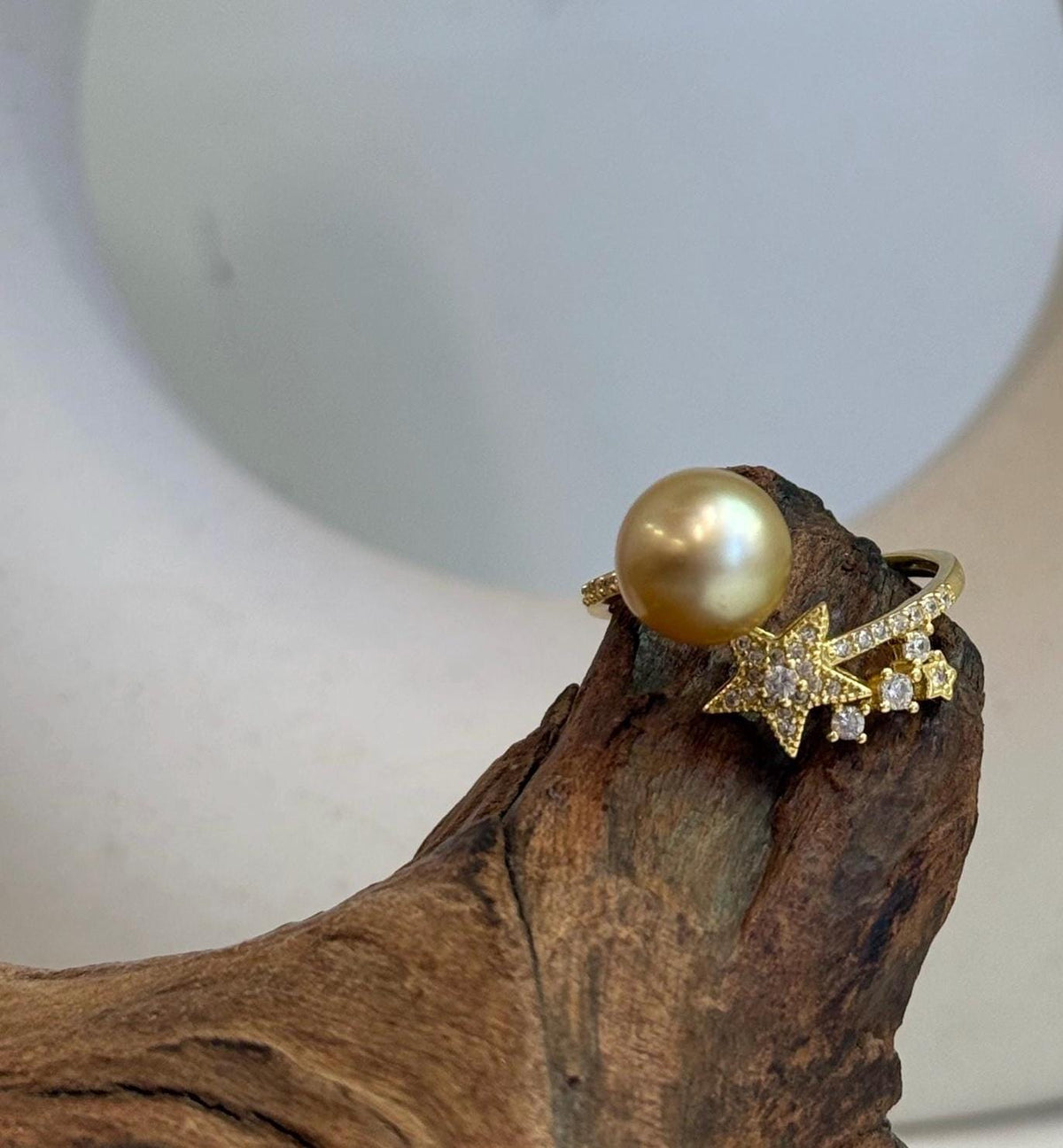 South Sea golden pearl with a highly reflective surface set in a star-design S925 silver ring with gold plating.
