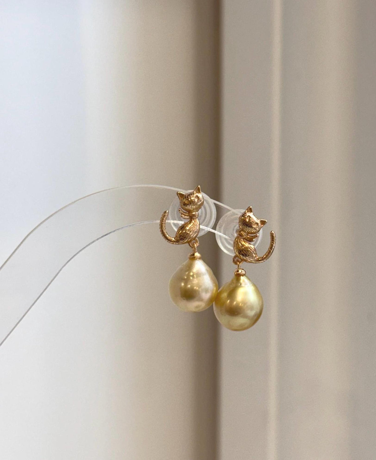 Deep tea golden South Sea pearl cat earrings with bright natural shine and detailed sterling silver setting.