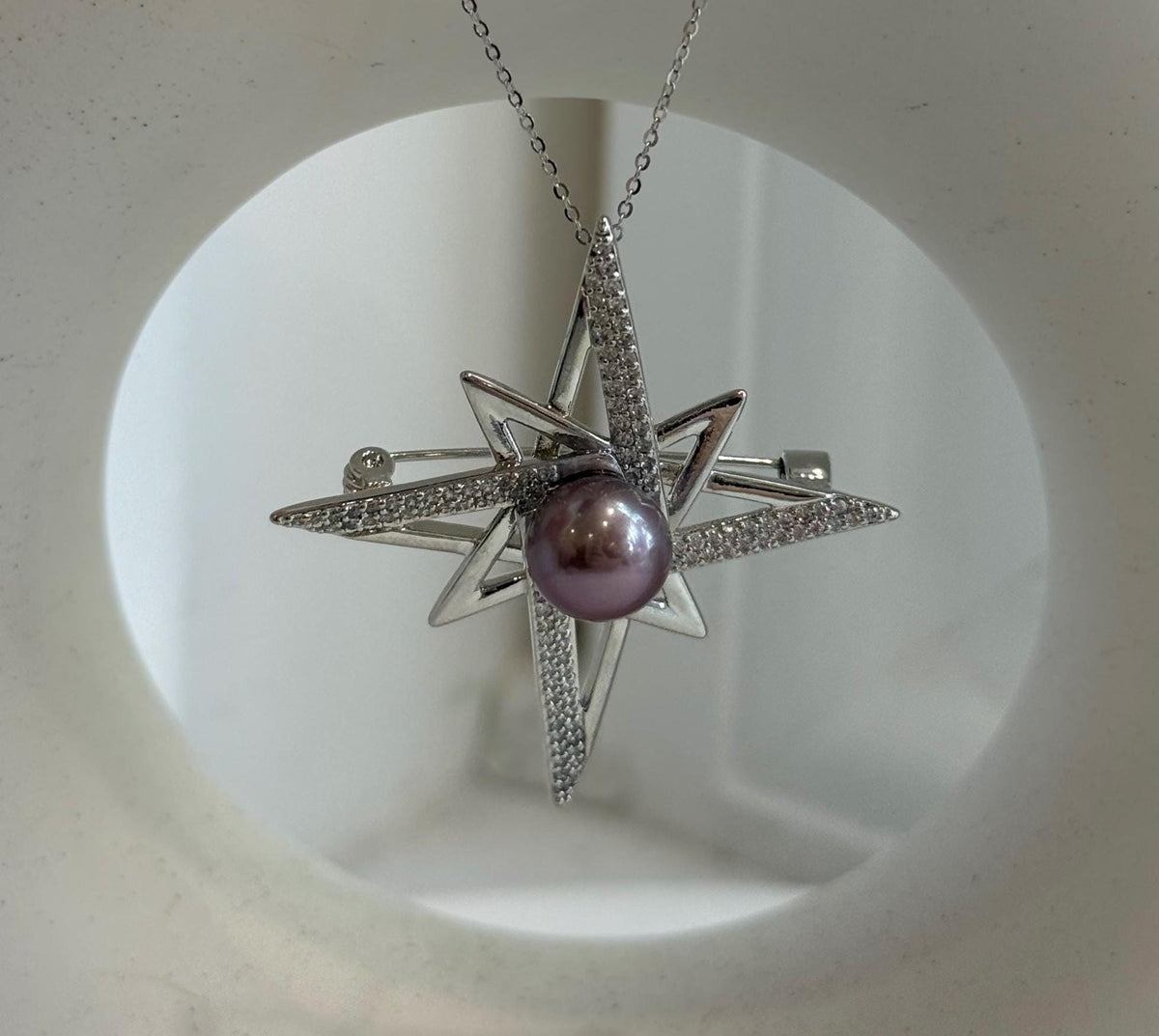 Purple Edison pearl reflecting light in the star setting.