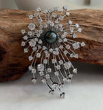 Tahitian piano black pearl set at the center of a fireworks-inspired brooch pendant.