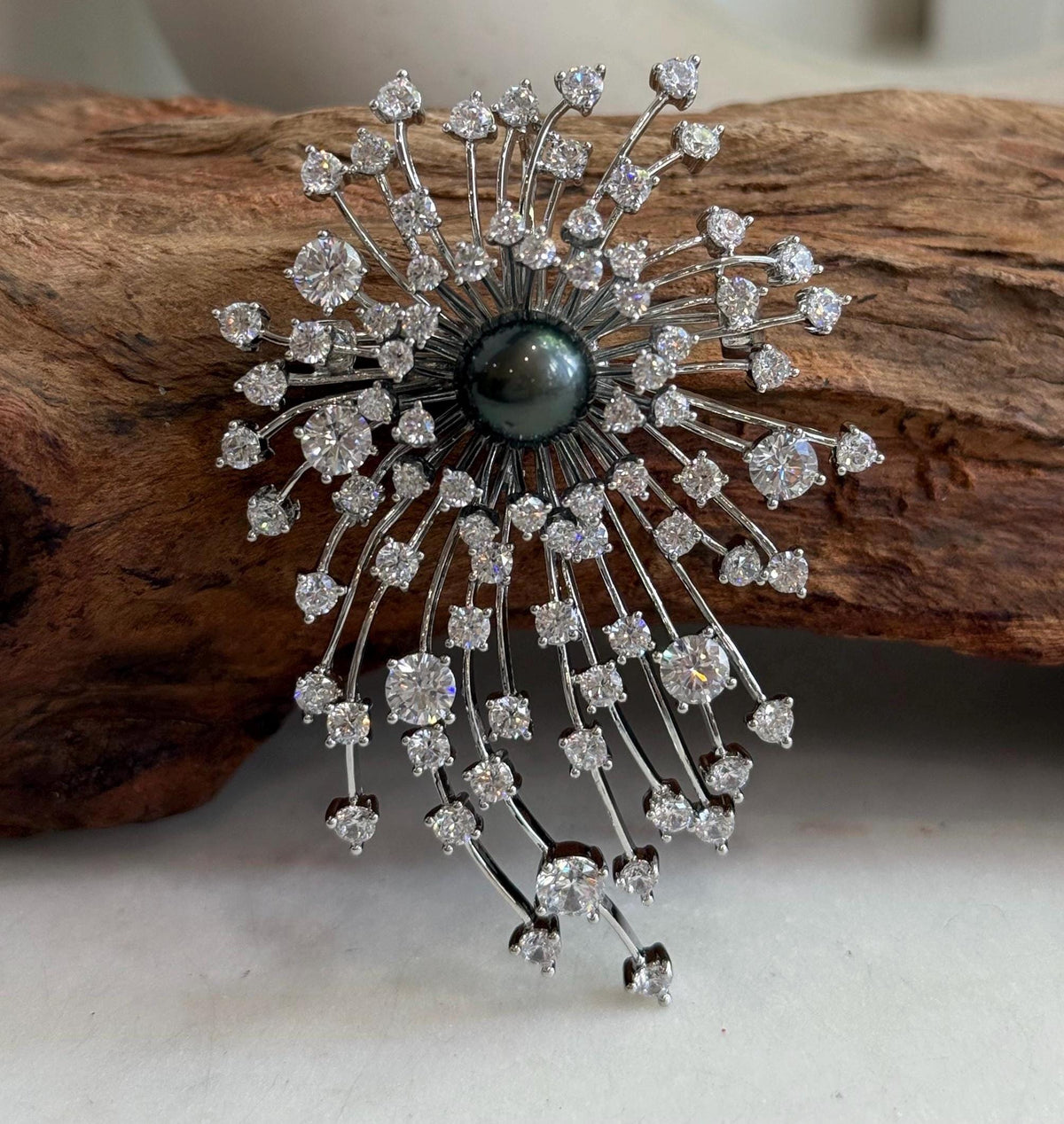 Tahitian piano black pearl set at the center of a fireworks-inspired brooch pendant.