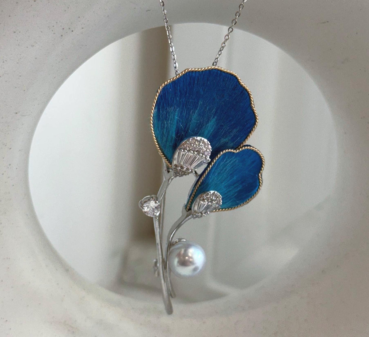 Close-up of a lustrous Akoya pearl with bright reflections and a soft iridescent glow.