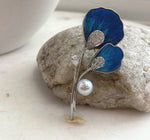 Two-in-one floral pearl jewelry piece designed to be worn as a brooch or pendant.