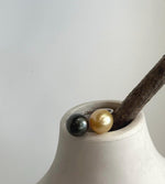 Front view of the adjustable two pearl ring on a light stone surface.