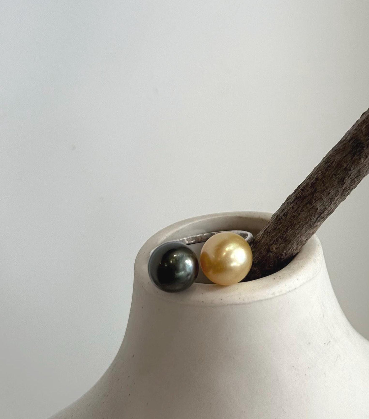 Side-by-side view of the contrasting pearls on an open sterling silver ring.