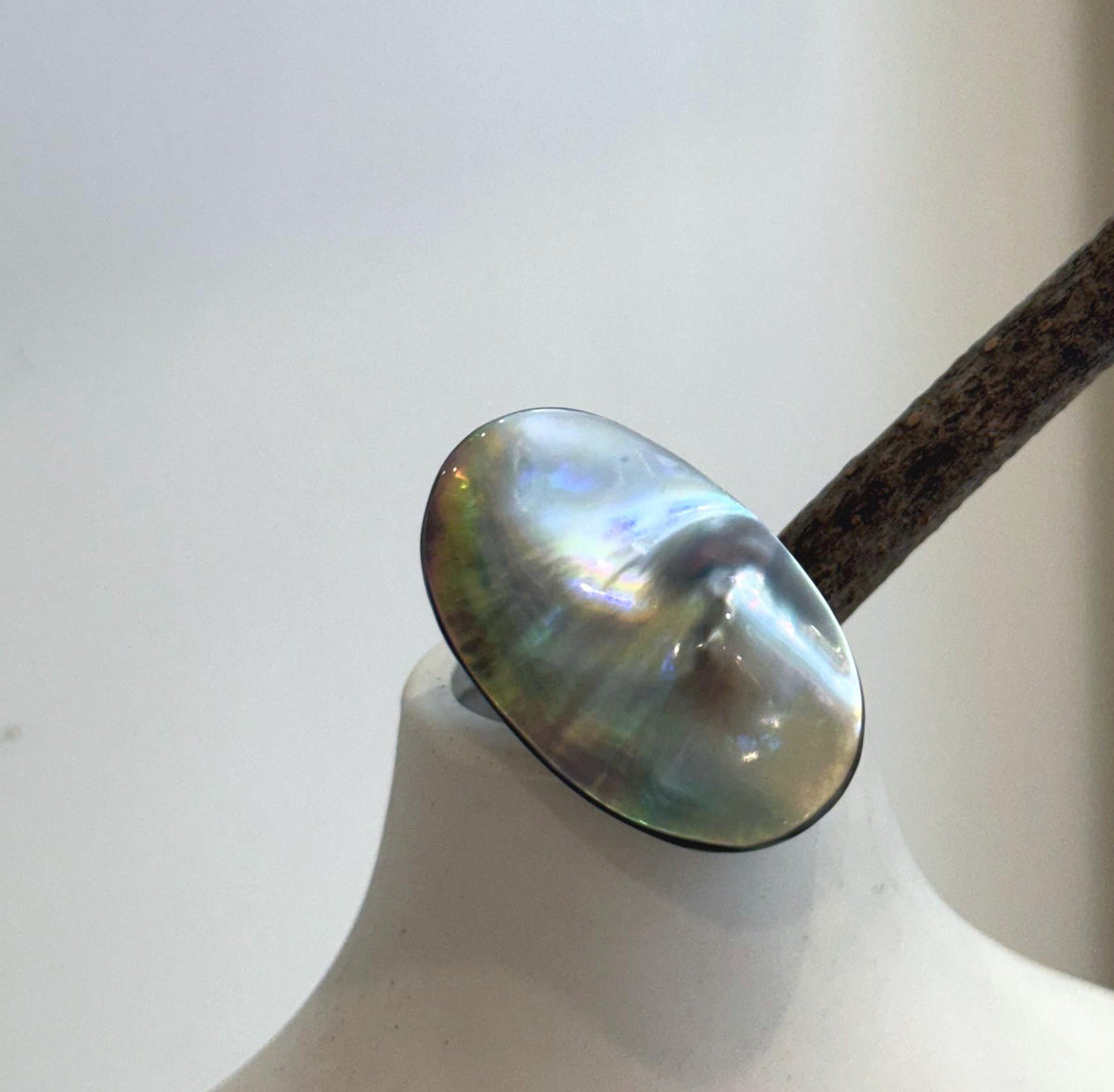 Large iridescent Mabe pearl ring with bright blue green flashes and elegant sterling silver setting