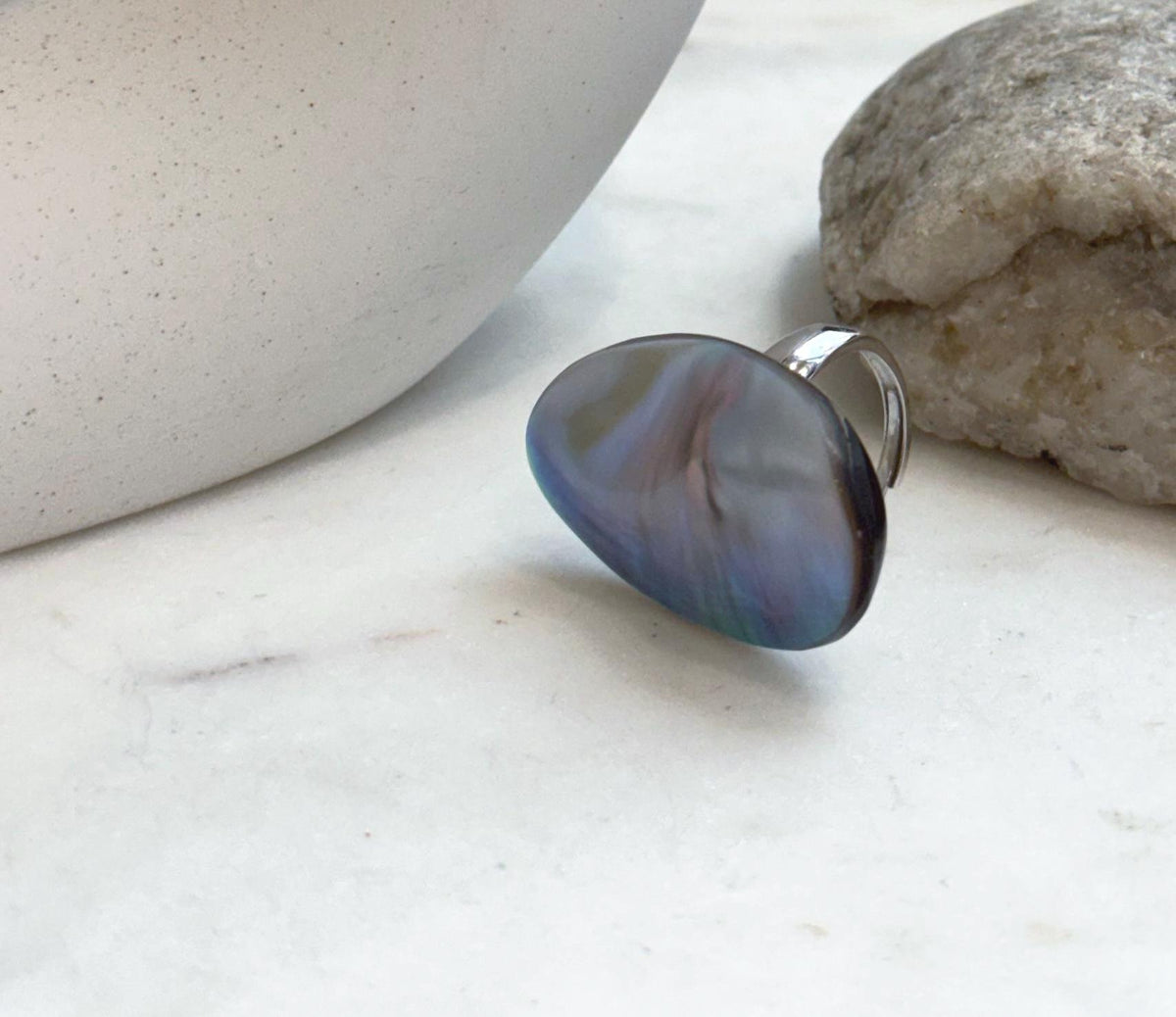 Adjustable sterling silver ring set with a luminous rainbow iridescent Ocean Mabe pearl