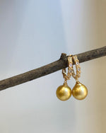 Golden South Sea pearl hoop earrings with crystal accents and a warm gold-tone finish.