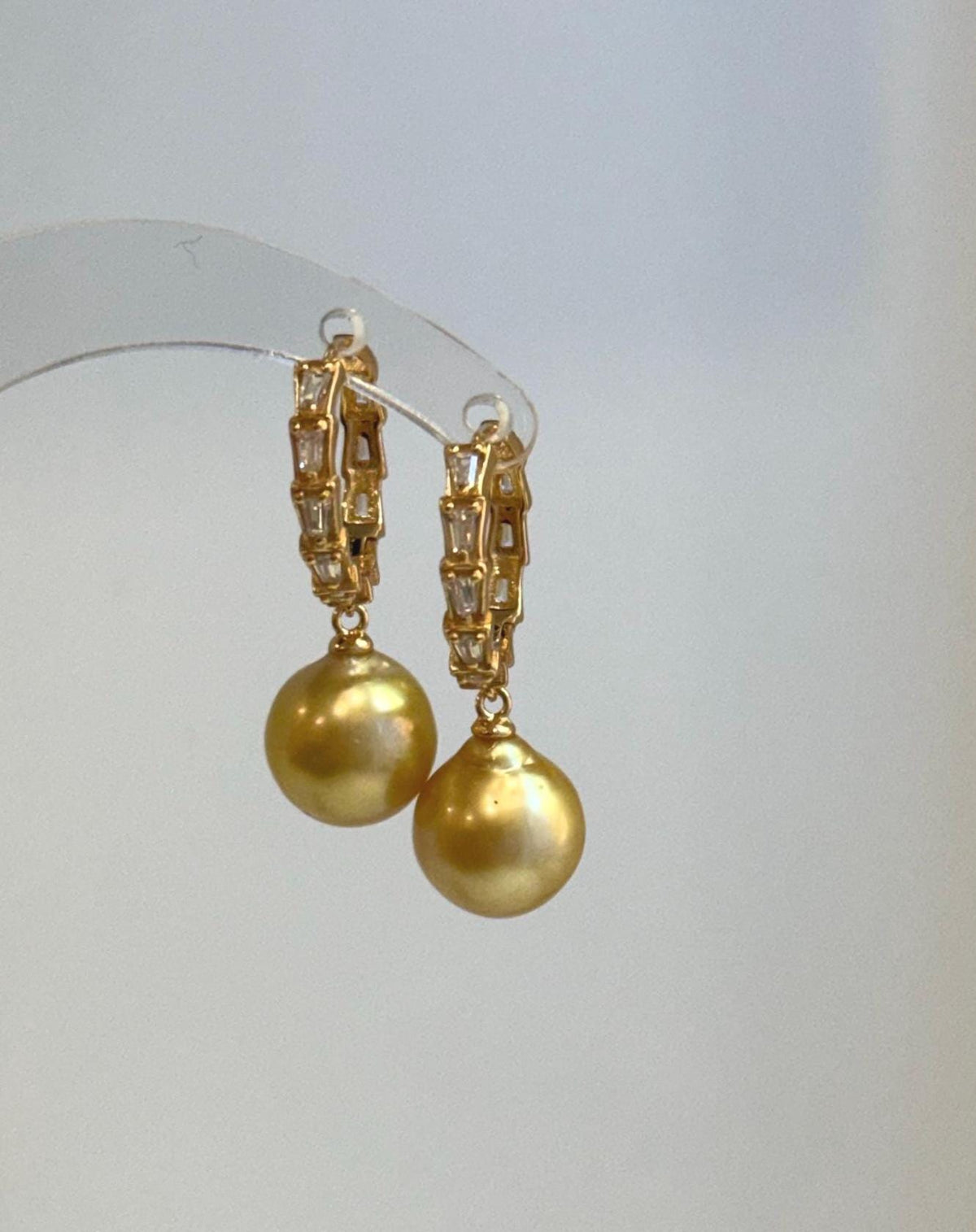 Gold-tone hoops frame luminous South Sea pearls for a classic evening look.