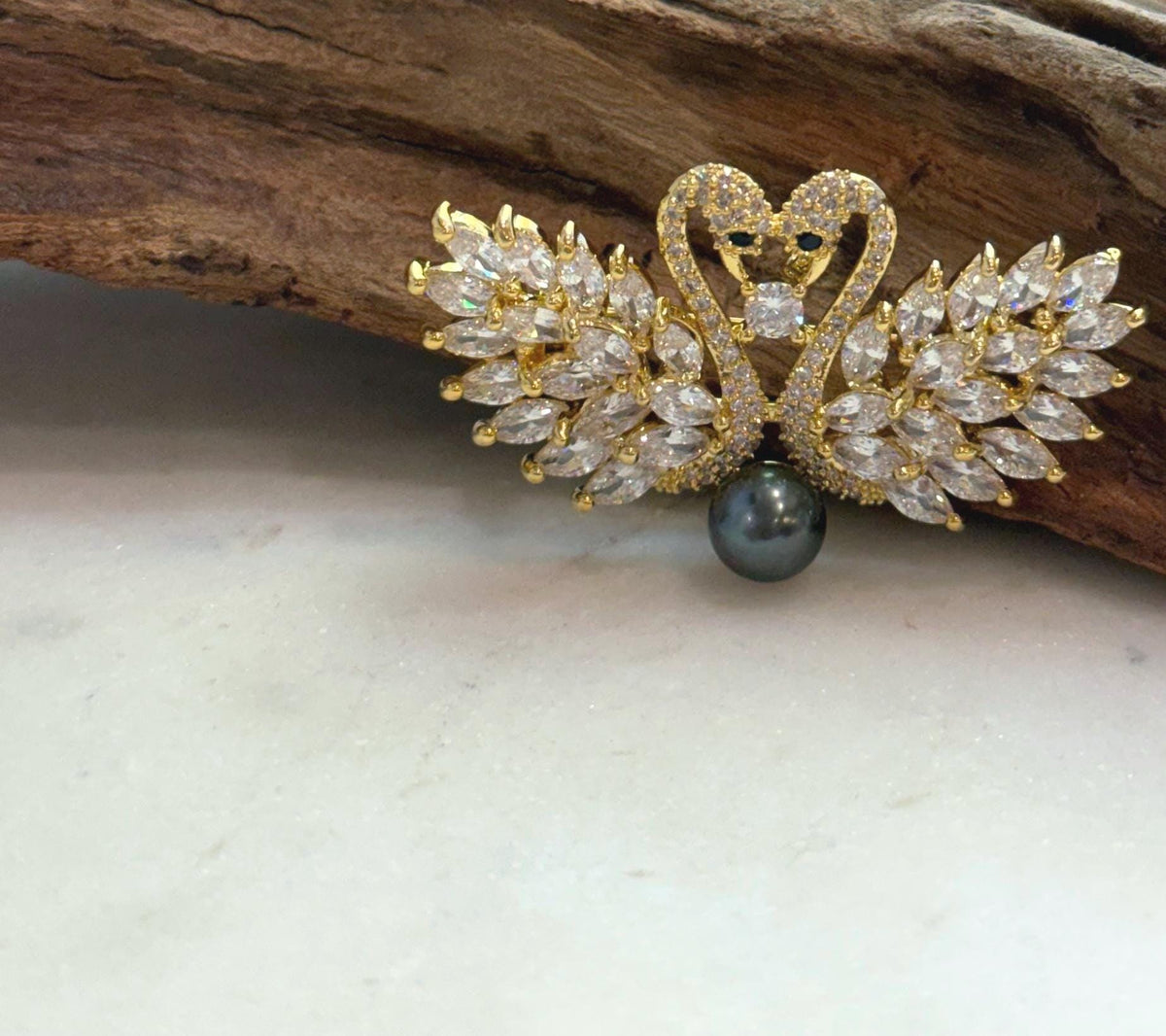 Detailed view of the pearl’s mirror-like reflections in the swan setting.