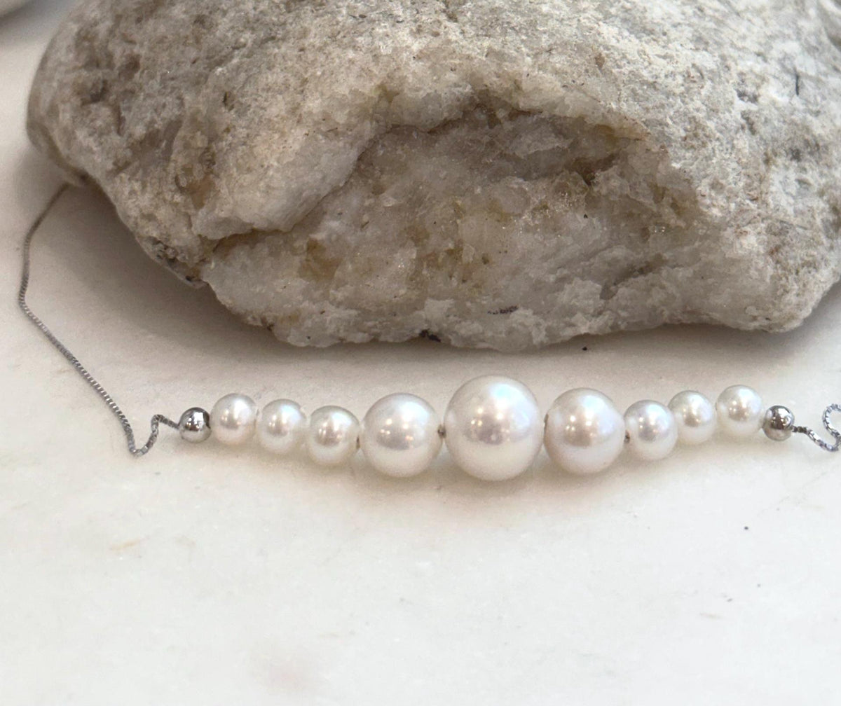 Minimalist white pearl smile necklace with ten genuine freshwater pearls arranged across a delicate chain.