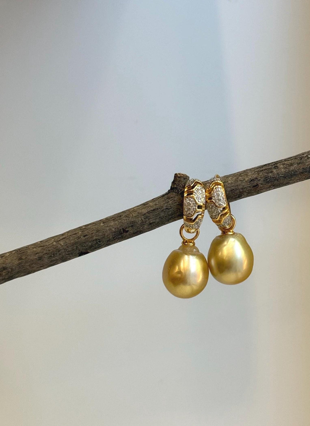 Pair of genuine saltwater pearl earrings with an elegant gold-tone setting.