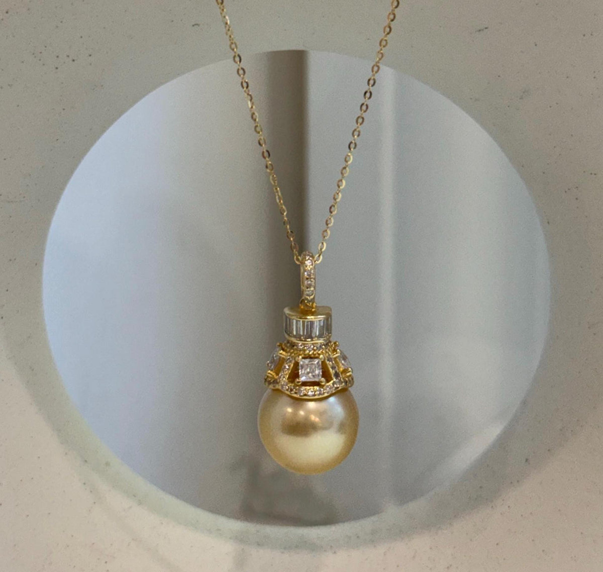 Golden South Sea pearl pendant necklace with a crystal-accented gold-tone setting.