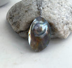 Close-up of the ocean Mabe pearl’s shifting iridescent colors