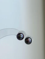 Minimalist purple pearl studs featuring genuine freshwater pearls and sterling silver settings.