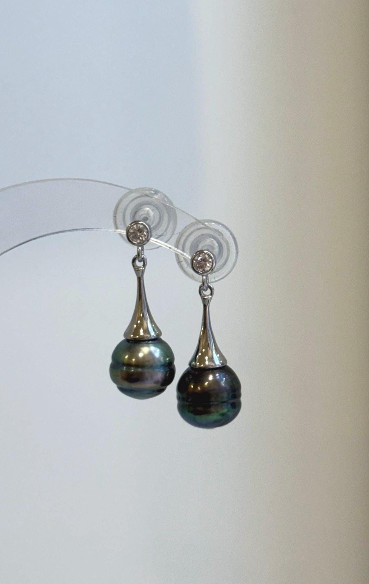 Pair of Tahitian pearl earrings with cool-toned sterling silver details.