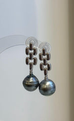 Close-up of two genuine Tahitian pearls showing platinum tones and mirror-like luster.