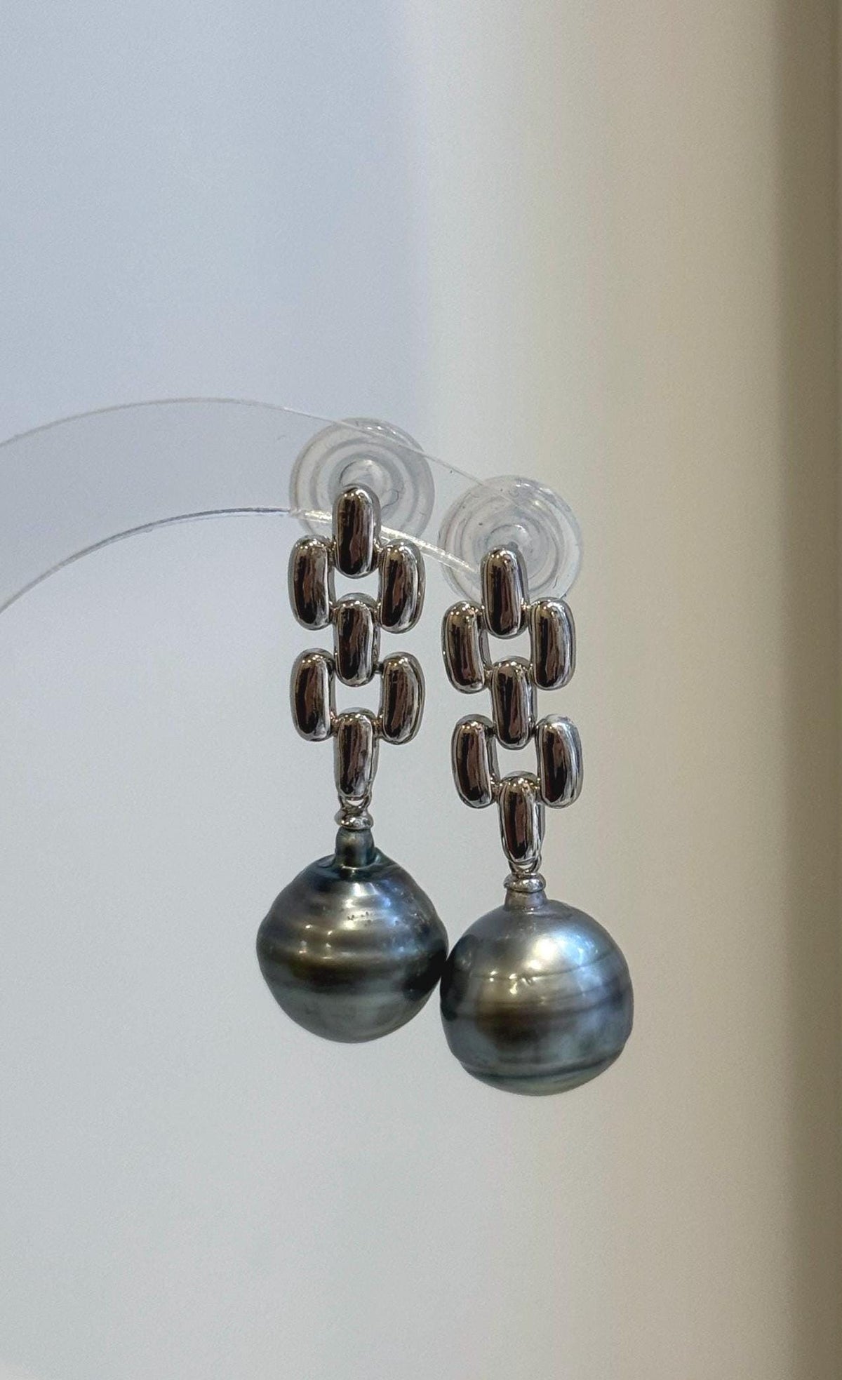 Close-up of two genuine Tahitian pearls showing platinum tones and mirror-like luster.