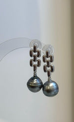 Pair of saltwater pearl earrings combining modern silver shapes with soft platinum color.
