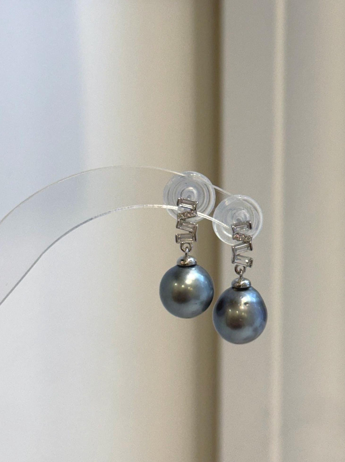 The geometric silver design frames each platinum-colored Tahitian pearl.