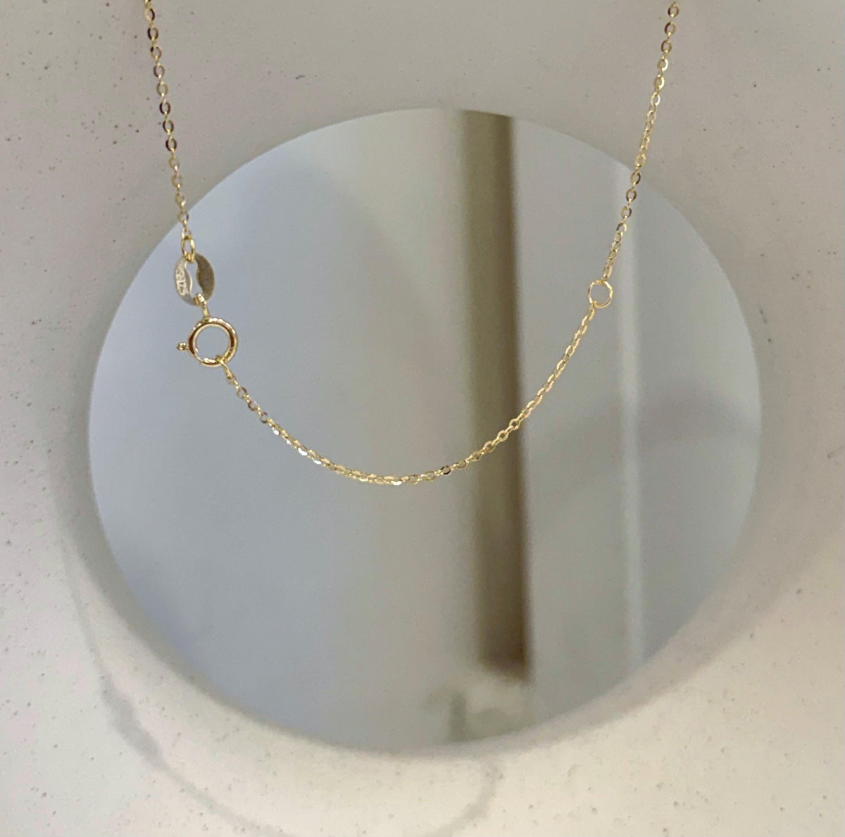 Close-up of the drop-shaped pearl’s warm golden colour and smooth surface.