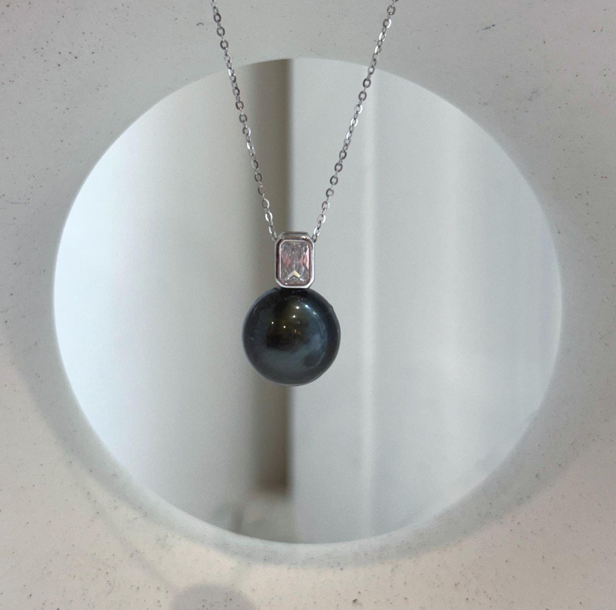 Black saltwater pearl necklace with sparkling crystals above the pearl