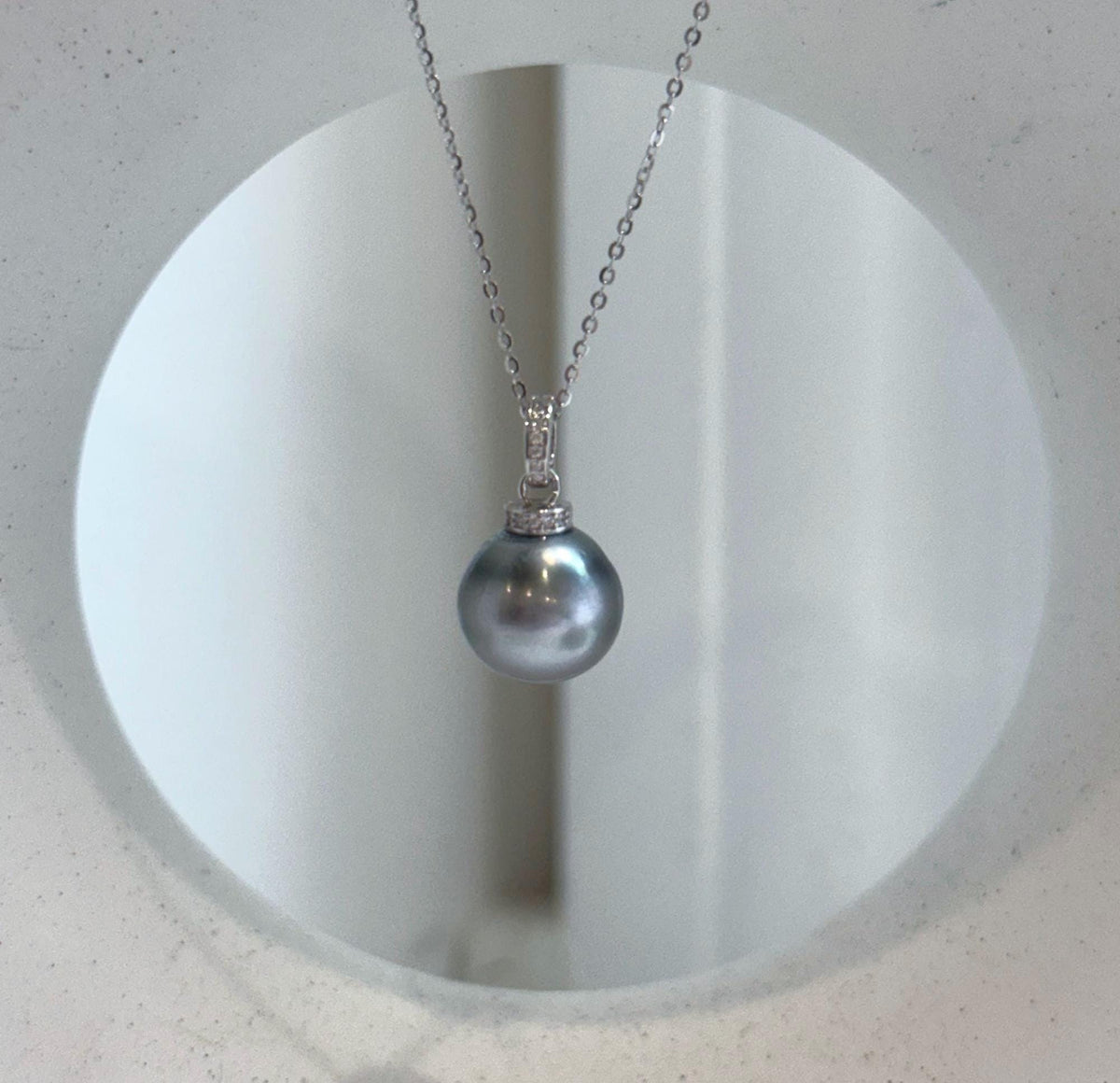 Close-up of a lustrous Tahitian pearl and its crystal-accented silver setting