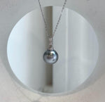 Close-up of a lustrous Tahitian pearl and its crystal-accented silver setting