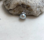 Persimmon-inspired sterling silver details above the silver taupe pearl.