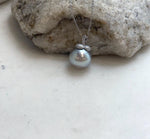 Detailed view of the pearl’s luster and persimmon-shaped pendant setting.