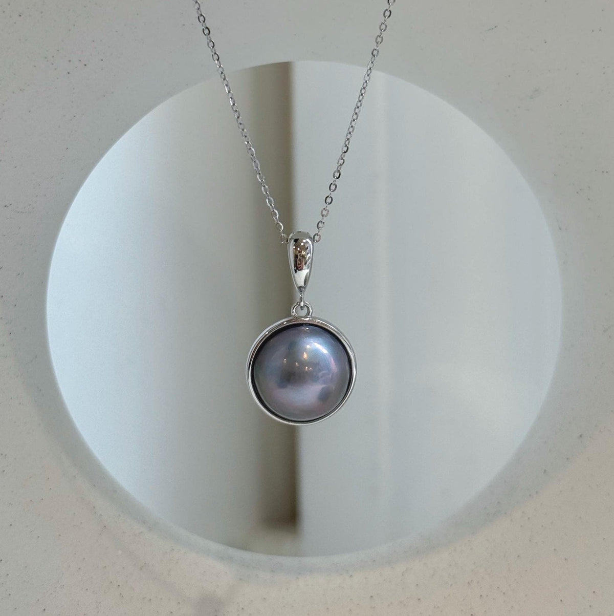 Platinum iridescent ocean round Mabe pearl pendant necklace with extreme mirror luster