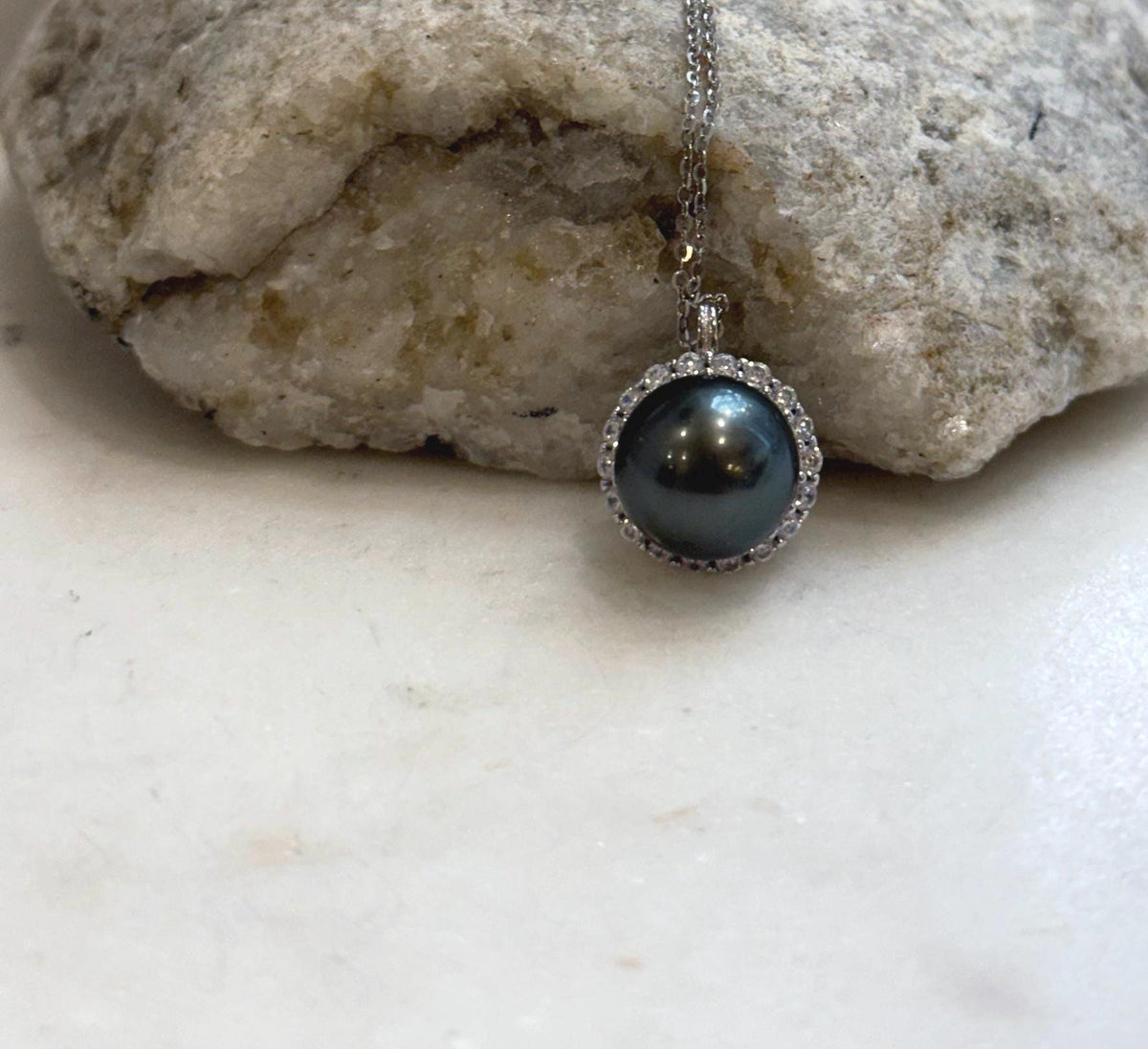 Crystal-framed Tahitian pearl hanging from a delicate silver chain.