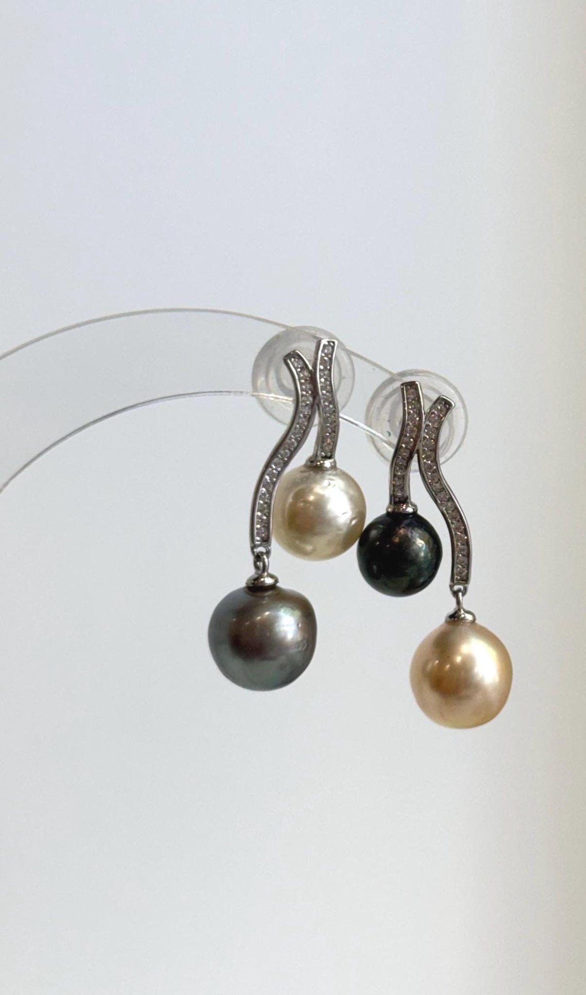 Golden and dark pearls on curved sterling silver earrings.