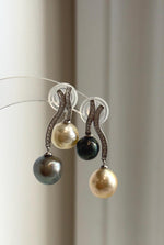 Asymmetric pearl earrings with sweeping sterling silver curves.