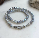 Blue grey pearl strand with a polished sterling silver clasp at the front.