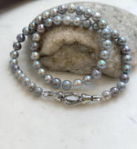 Reflective silver blue pearls with subtle variations in shape and colour.