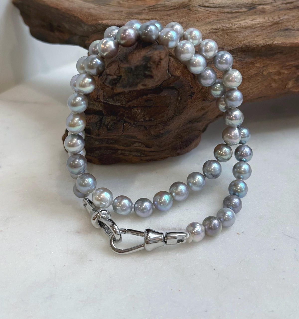 S925 sterling silver clasp connecting a lustrous blue grey pearl strand.